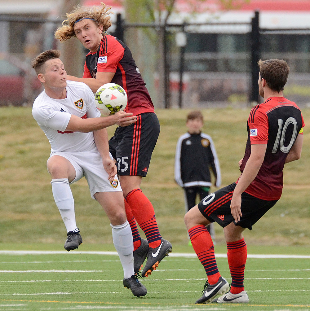 Calgary Foothills FC's Dominic Russo, left, and Portland Timbers U23's Kyle Adams, centre, battle for the ball during their Premier Development League match at Hellard Field in Calgary Tuesday, June 2, 2015