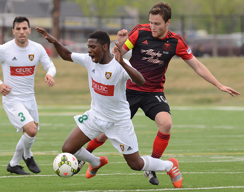 Calgary Foothills FC's Elijah Adekugbe, #8, is fouled by Portland Timbers U23's Todd Wharton during their Premier Development League match at Hellard Field in Calgary Tuesday, June 2, 2015