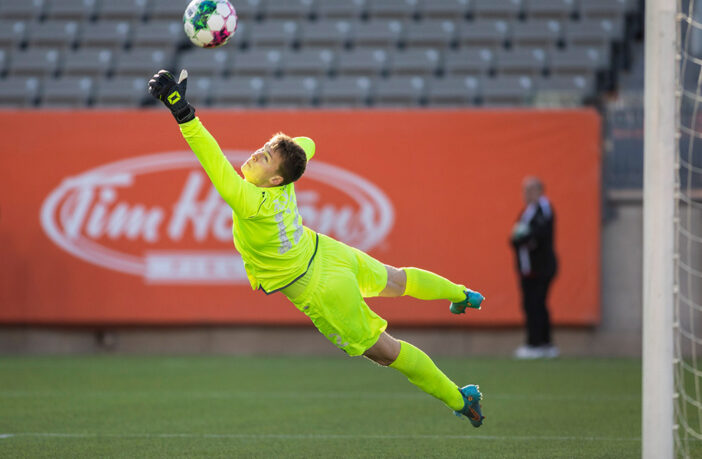 A Forge FC ball gets past Cavalry FC goalkeeper Julian Roloff (12) during Canadian Premier League play at Tim Hortons Field in Hamilton, Ont., on Saturday, April 16, 2022. Photo by Nick Iwanyshyn/Total Soccer News